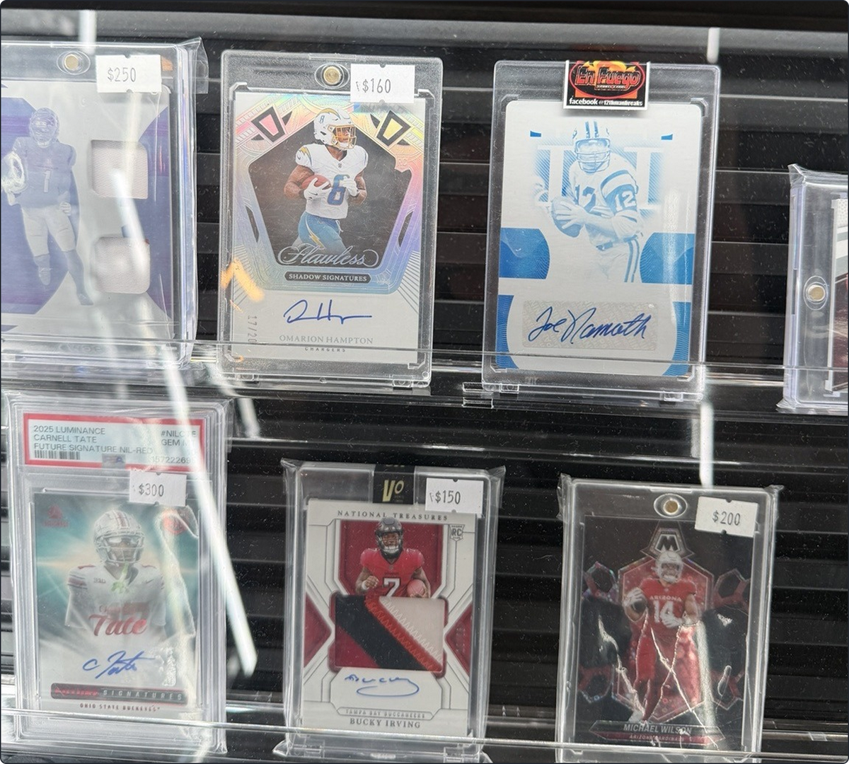 Part of the RIP Valley display case, with the Omarion Hampton Flawless and Bucky Irving National Treasures autographs among other cards. The stickers are asking prices.